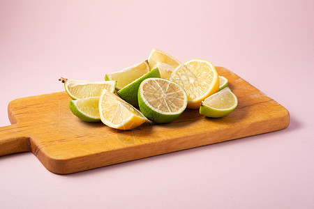 粉红色背景的鲜柠檬和柠檬水果切片果汁团体粉色黄色创造力食物饮食绿色热带甜点图片