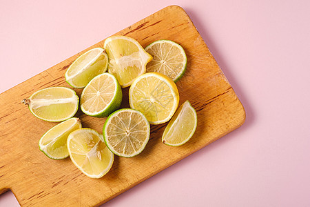 粉红色背景的鲜柠檬和柠檬水果切片粉色团体绿色黄色果汁饮食创造力甜点食物热带背景图片