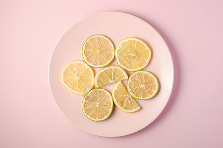 粉红色背景的鲜柠檬和柠檬水果切片团体食物果汁饮食绿色甜点黄色粉色创造力热带背景图片