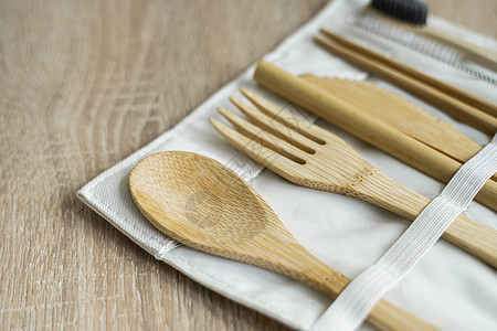 放在桌子上的盒子里的环保竹制餐具 零废物概念 一套竹制餐具放在桌子上的一个盒子里 勺子 叉子 刀 牙刷 管子和中国棍子刷子野餐用图片