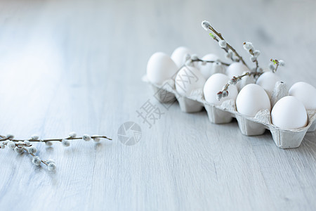 白色鸡蛋放在一个开放的纸板箱里 背景是浅色的 上面装饰着带有柔软白芽的柳枝 一打环保包装的鸡蛋 健康的有机食品和饮食理念 复活节图片