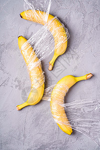 在石块混凝土上包装成塑料包裹的香蕉水果图片