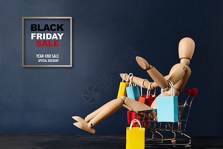 黑色星期五销售 黑周五出售 木娃娃坐在购物车上和Sho一起商业市场世界店铺价格零售电子商务顾客折扣互联网图片