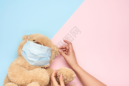 穿戴医疗面具的泰迪人 蓝粉色背景 概念o图片