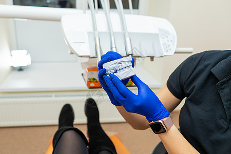 美丽的专业女孩 医生牙医整牙学家展示了下巴的石膏印象假肢手套治疗病人模具牙科矫正职业牙齿图片