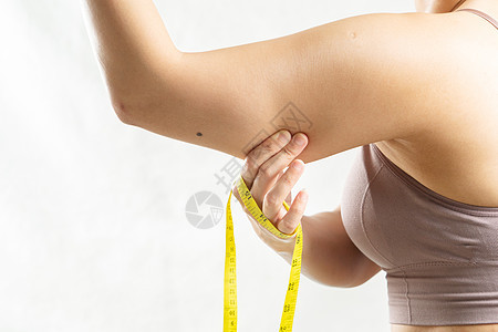 女人手握着她过度脂肪的手臂 用mea重量食物橘皮紧缩腰部身体损失女士糖类饮食图片