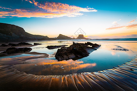日落日出旅行地平线晴天岩石波浪蓝色太阳海滩反射图片