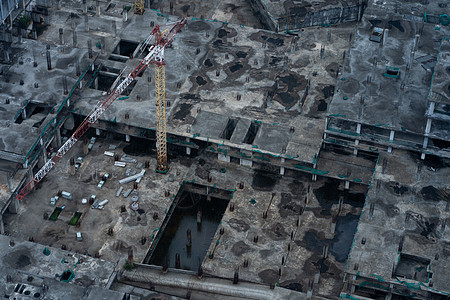 雨后大型建筑物的建筑工地的最顶端 管道被开进 下面的楼层被建造财产工程师起重机进步材料头盔机器商业脚手架天线图片