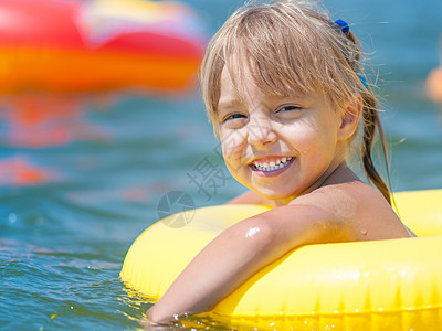 海上的小女孩假期圆圈戒指游泳孩子闲暇微笑幸福婴儿晴天图片