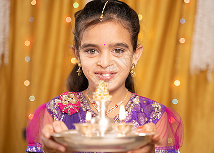 在印度宗教节庆仪式上 对穿着传统服装的可爱小女孩拍了POV照片 在做Arti或为上帝提供光明图片