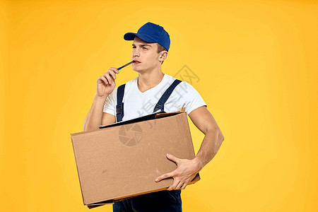 身穿制服 带箱式手送货装货服务的工人 黄色背景包装盒子商务纸盒成人重量人士纸板货物邮件图片