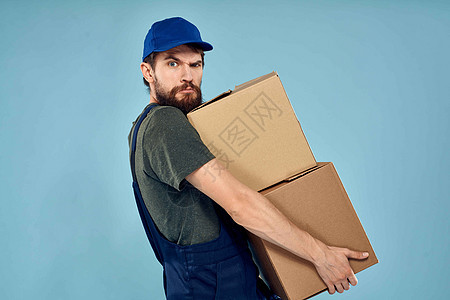 身穿制服和手递服务用箱装纸箱的男工男人盒子工作室重量货物工人纸盒成人送货领带图片