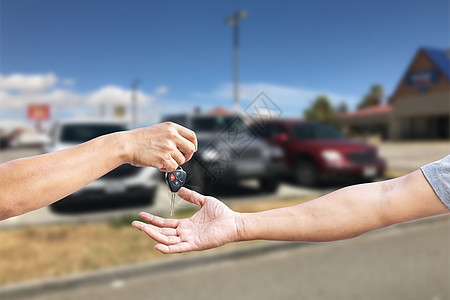 一个男人的手在给另一个男人的腿 提供一辆汽车钥匙遥控人士商业车库男性商务顾客司机钥匙保险图片