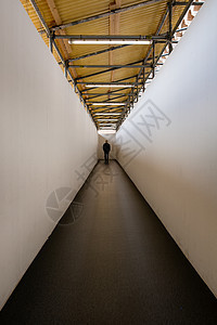 男人走在走廊上 走向光亮的终点出口图片