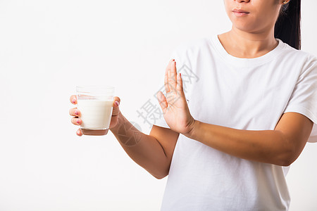 女人举手阻止手牌 用手握着玻璃牛奶痛苦手势饮食疾病过敏腹部症状乳糖产品病人图片
