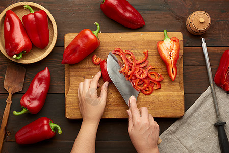 女人把红铃辣椒切成木板上的碎片厨师食物女士营养蔬菜女性桌子红色沙拉厨房图片