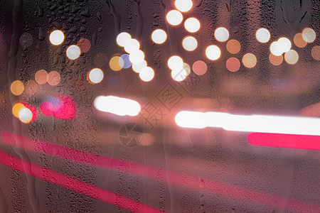车在雨后移动时有突出重点的头灯运动街道玻璃辉光背景交通阴雨反射天气窗户图片