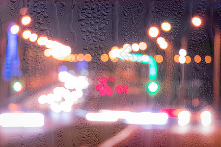 车在雨后移动时有突出重点的头灯阴雨雨滴反射交通汽车城市街道流动玻璃天气图片