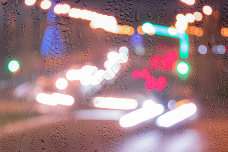 车在雨后移动时有突出重点的头灯街道交通窗户背景反射城市天气阴雨汽车玻璃图片