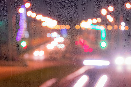 车在雨后移动时有突出重点的头灯汽车城市反射运动窗户背景阴雨雨滴液体天气图片