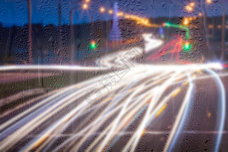 车在雨后移动时有突出重点的头灯辉光汽车天气玻璃反射交通城市背景液体运动图片