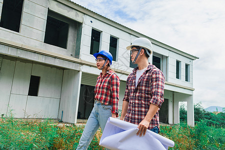 年轻的亚裔夫妇工头工程家主房检查大楼成人建筑学维修男人建筑师修理工项目帽子工作头盔图片