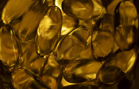 鱼油橙黄色软胶囊鱼油欧米茄 3 或欧米茄 6 欧米茄 9 维生素 A 维生素 D 维生素 E 背景的极端特写 健康的维生素产品概图片