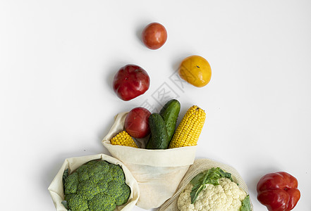 白色表面生态袋中的蔬菜 胡椒 西红柿 玉米 黄瓜 西兰花 花椰菜 装在可重复使用的购物环保棉布袋中 零废物和无塑料概念 可持续的图片