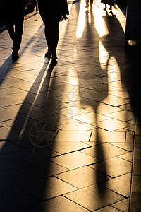 日落时在人行道上投射长长的人类阴影石头男人数字行动阳光生活城市社区行人正方形图片