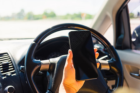 亚洲女性在车内 开车时手持手机空白屏幕图片