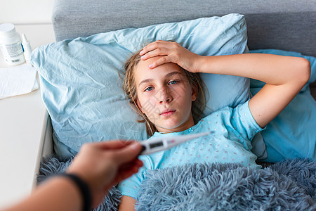高发高烧和头痛生病的十几岁少女躺在床上女孩发烧感染说谎卫生童年毯子孩子保健温度计图片