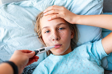 患有高发烧和头痛患病的十几岁少女躺在床上 将温度计放在嘴里药品孩子治疗流感女性感染温度卫生毯子说谎图片