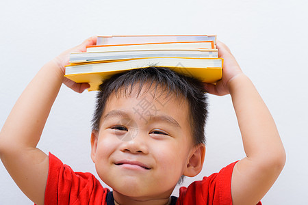 回到学校 亚洲学生男孩书 平衡的堆叠书图片