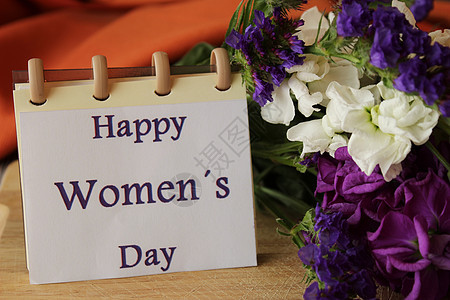 妇女节送百合花和蜡菊花 笔记本上的快乐妇女节消息书法植物群女性礼物紫色纸条花束庆典国际假期图片