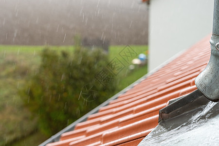 在暴风雨中 雨水从屋顶水沟里流下来 流动着房子排水沟宏观摄影烟囱气候天气建筑环境气候变化图片