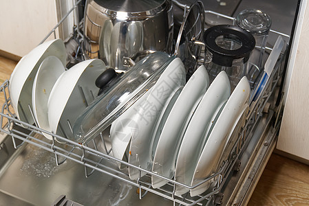 开放式集成洗碗机中的脏盘子 清洗前打开洗碗机 里面放着脏盘子 满载的洗碗机准备清洗家庭银器工作器皿房子厨具刀具勺子机器杯子图片