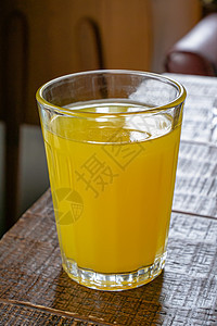 一杯棕色桌上的新鲜橙汁饮料图片