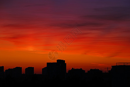 明亮的橙色夕阳在城市上空在晚上 城市高楼大厦灯火通明 在建建筑城市起重机剪影 选择性聚焦阳光中心商业日落摩天大楼蓝色天空景观旅行图片