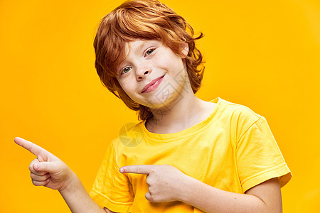 黄色T恤衫复制空间中有趣的红头发男孩前视线图片