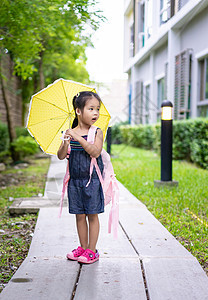 带着雨伞和背包的小女孩 在公园里行走 准备就绪图片