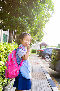 小女孩背着背包走在停车场 准备回到scho图片