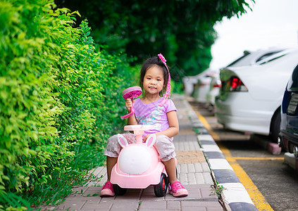亚洲小女孩喜欢在人行道上玩车弹性孩子们喜悦幼儿园操场娱乐乐趣女孩城堡闲暇图片