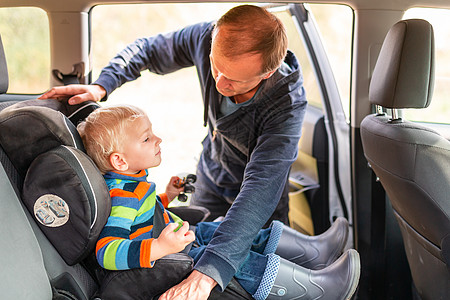 父亲在车座上为儿子系紧安全带家庭婴儿碰撞警告运输车辆男生座椅驾驶事故图片