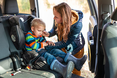 母亲系紧安全带 让小男孩坐在车座上家庭椅子驾驶碰撞汽车座位事故带子儿子座椅图片