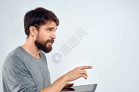 一个手手里拿着平板电脑的男人 互联网科技通讯灰色夹克光背景的白衣白色衬衫软垫药片微笑商业快乐工作室成人技术图片