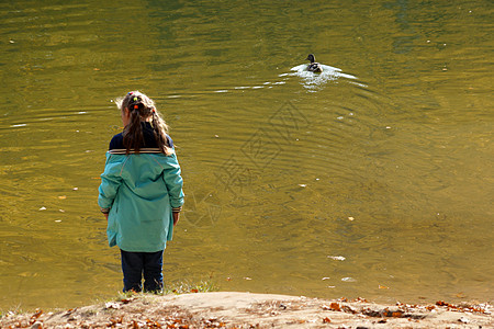 女孩站在湖边 看着浮鸭子 (笑)图片