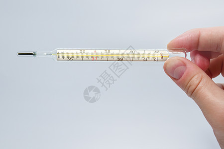 蓝色背景中孤立的男人手中的水银温度计 使用温度计测量温度 高烧和疾病 特写图片