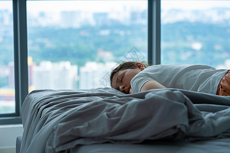 女孩中午在床上不小心睡着了 该女孩睡了觉公寓床单闲暇寝具成人睡衣就寝黑发休息小憩图片