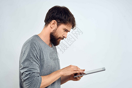 一个手手里拿着平板电脑的男人 互联网科技通讯灰色夹克光背景的白衣技术药片快乐成人衬衫白色商业公司工作室商务图片