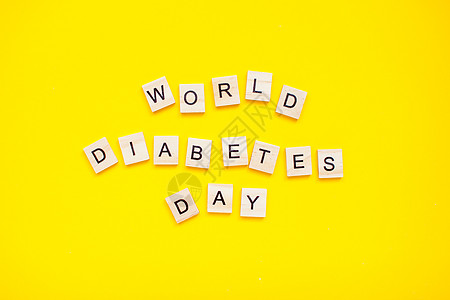 黄色背景下的世界糖尿病日的木块刻字 (笑声)图片